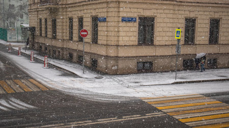 Snowfall in the city, roads, houses.