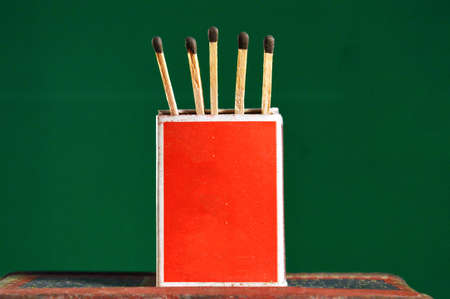 Wooden matchsticks with box stand with green background