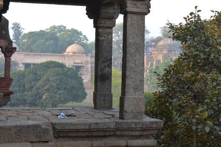A sun create some dramatic view of fort, monument at hauz khas memorial from the side of the lawn at winter foggy morning.の写真素材