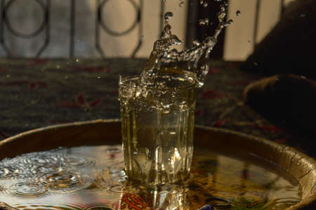 A splash photography of water of glass at sunset time.の写真素材