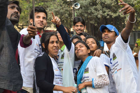 A group of indian people poses for support the cycle ride to celebrate international women's day.のeditorial素材