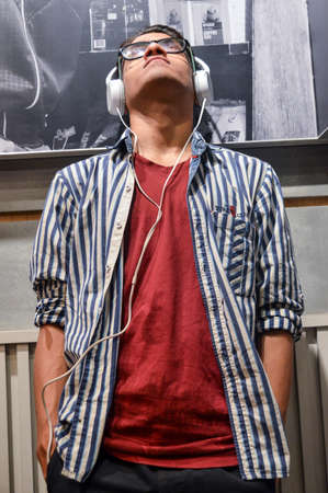 Indian boys giving poses for fashion photo shoot on studio with using specs, headphone, light bulb props.の写真素材