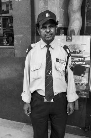 A portrait of old man security guard is standing outside of his job for money.のeditorial素材