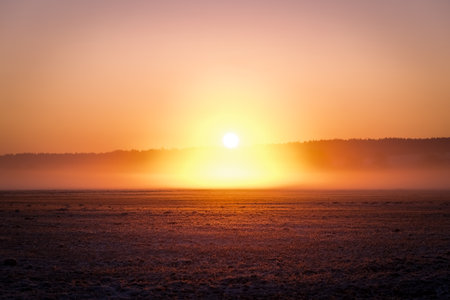 Foggy sunrise over the field in winter. Beautiful landscape.の写真素材