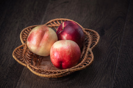 Still life of fresh peaches and apples on a dark background.の写真素材