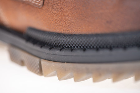 Fragment of fashionable men's brown winter boot made of genuine leather with fur.の写真素材