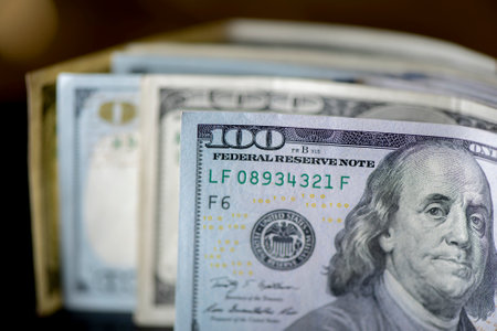 A lot of American dollars banknotes on a dark background.