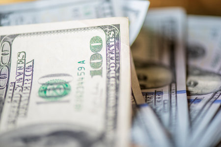 A lot of American dollars banknotes on a dark background.