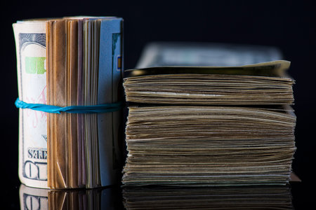 A lot of American dollars banknotes on a dark background.の写真素材