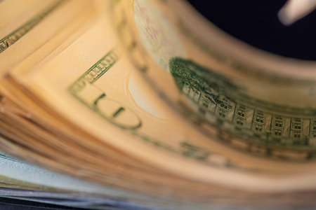 A lot of American dollars banknotes on a dark background.