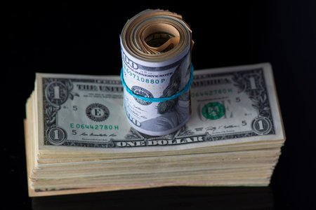 A lot of American dollars banknotes on a dark background.の写真素材