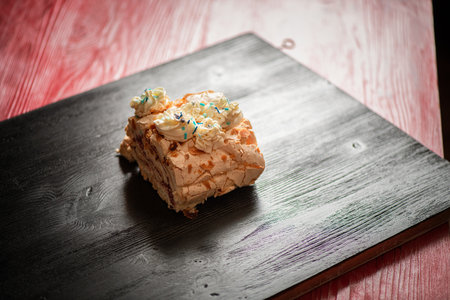 A piece of delicious organic homemade biscuit cake, on a wooden background close-up.