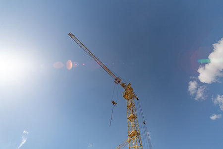 High tech construction crane against the blue sky.の写真素材