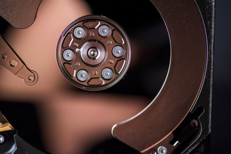 Component parts of a disassembled hard drive, close-up on a dark background.の写真素材