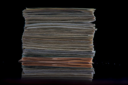 A stack of paper on a dark background. Photographed close-up.の写真素材