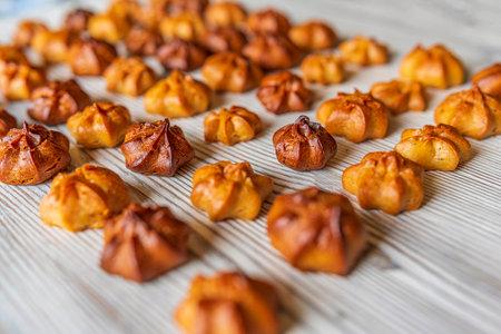 Choux pastry on a light wooden background. Photographed close-up.