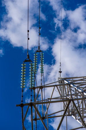 Power line against the blue sky and clouds.