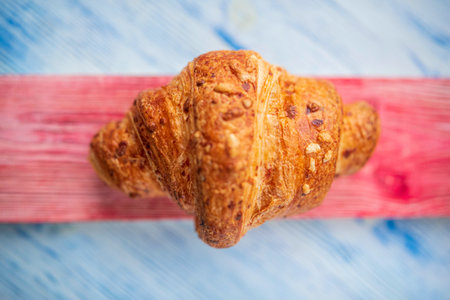 Croissant on a light wooden background. Photographed close-up.の写真素材