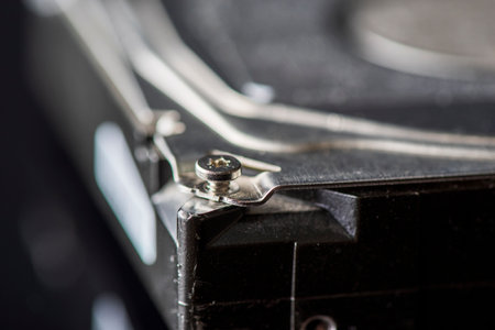 Disassembled hard drive. Spare parts from the hard drive. Photographed close-up against a dark...
