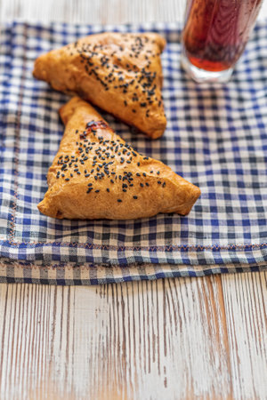 Samsa with meat on a napkin, next to a glass of juice. Photographed from above close-up.の写真素材