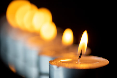 Several candles burning in a row. Photographed close-up.の写真素材