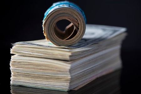 A stack of paper American dollars, photographed in close-up.