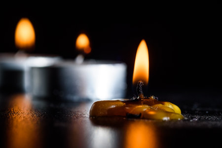 A burning candle against a dark background close-up.の写真素材