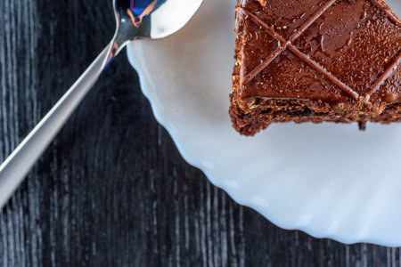 Chocolate brownies on a white plate on a black wooden backgroundの写真素材