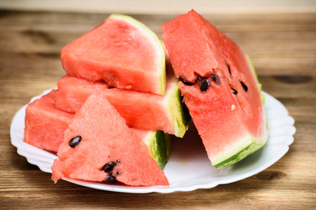Slices of watermelon on a plate on a wooden backgroundの写真素材