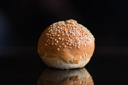 Bun with sesame seeds on a black background.の写真素材