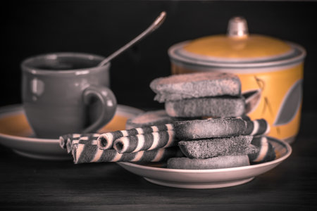 Cookies and cup of tea on wooden table. Toned.