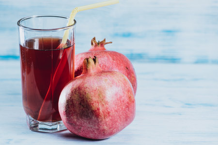 Pomegranate juice in a glass on a blue wooden backgroundの写真素材