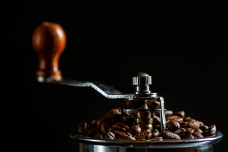 Coffee grinder and coffee beans on a black background.