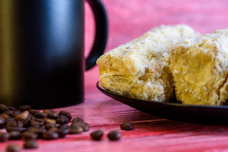 Napoleon cakes a cup of coffee on a red wooden background.の写真素材