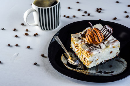 Pecan cake with cup of coffee on white wooden background.