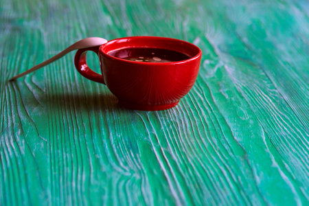 A cup of coffee on a green wooden background.の写真素材