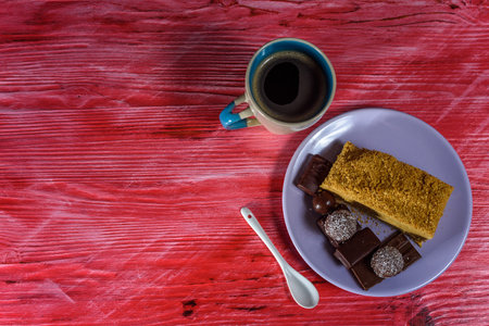 Puff cake, chocolates and coffee mug on vintage wooden background.の写真素材