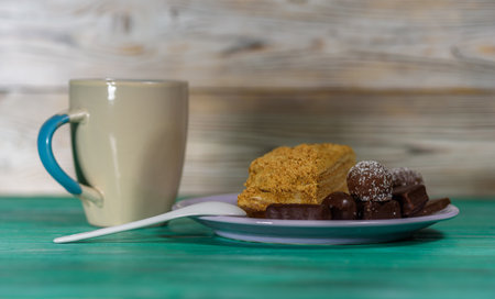 A piece of sponge cake lying on a plate, on a wooden background.の写真素材