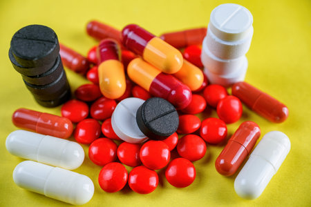Pills and tablets on a yellow background. Close-up.