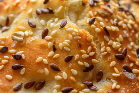 Bread with sesame seeds as background, closeup of photo