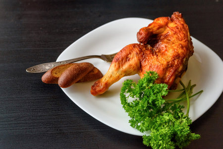fried chicken on a white plate on a dark wooden background