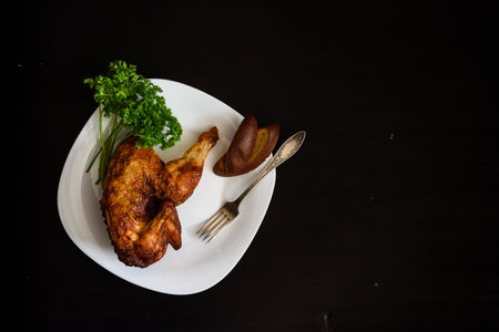 baked chicken on a plate, on a black backgroundの写真素材