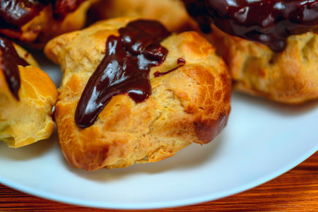 Profiteroles with chocolate on a white plate close-up.の写真素材