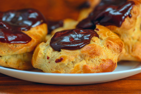 Scones with chocolate on a plate on a wooden table.の写真素材