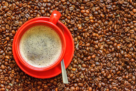 a cup of coffee on a background of coffee beansの写真素材