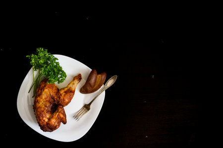 baked chicken on a plate, on a black backgroundの写真素材