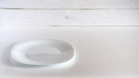 white plate on a wooden backgroundの写真素材
