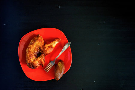 grilled chicken on a red plate on a wooden backgroundの写真素材