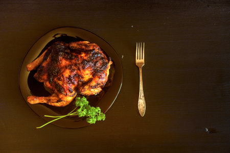 baked chicken on a dark wooden background.の写真素材