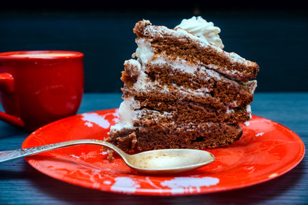 Chocolate cake with whipped cream and cup of coffee on wooden tableの写真素材